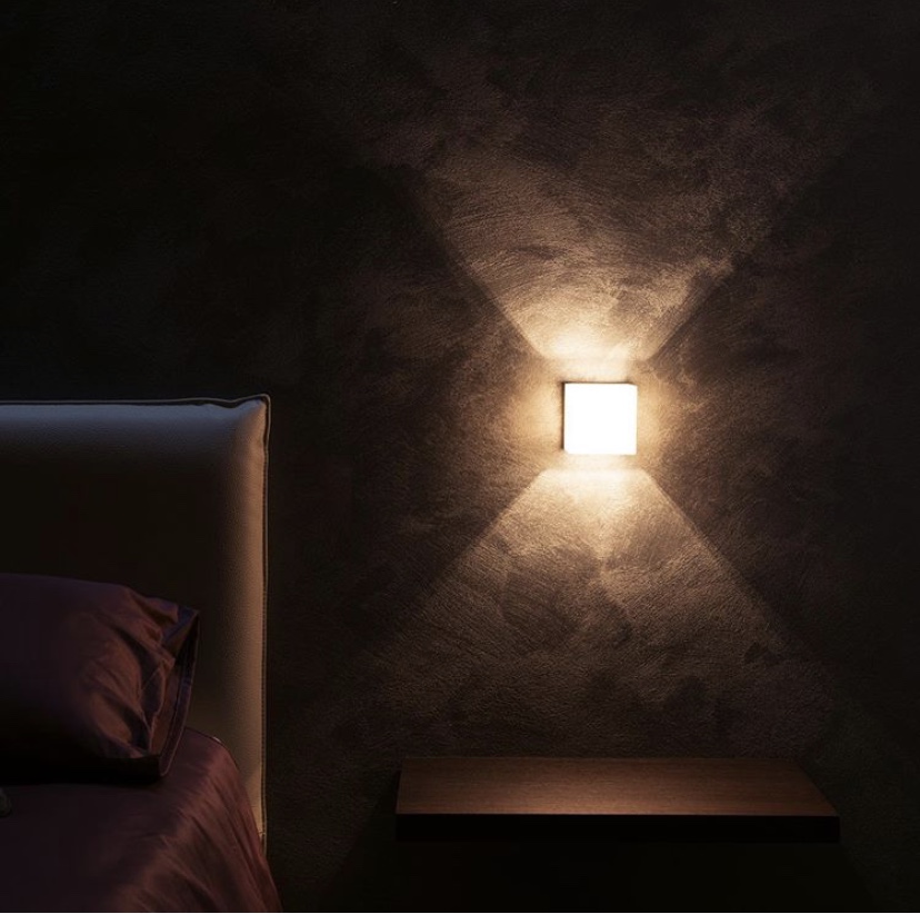 Dettaglio della parete e dell’illuminazione accanto al letto della Camera King
